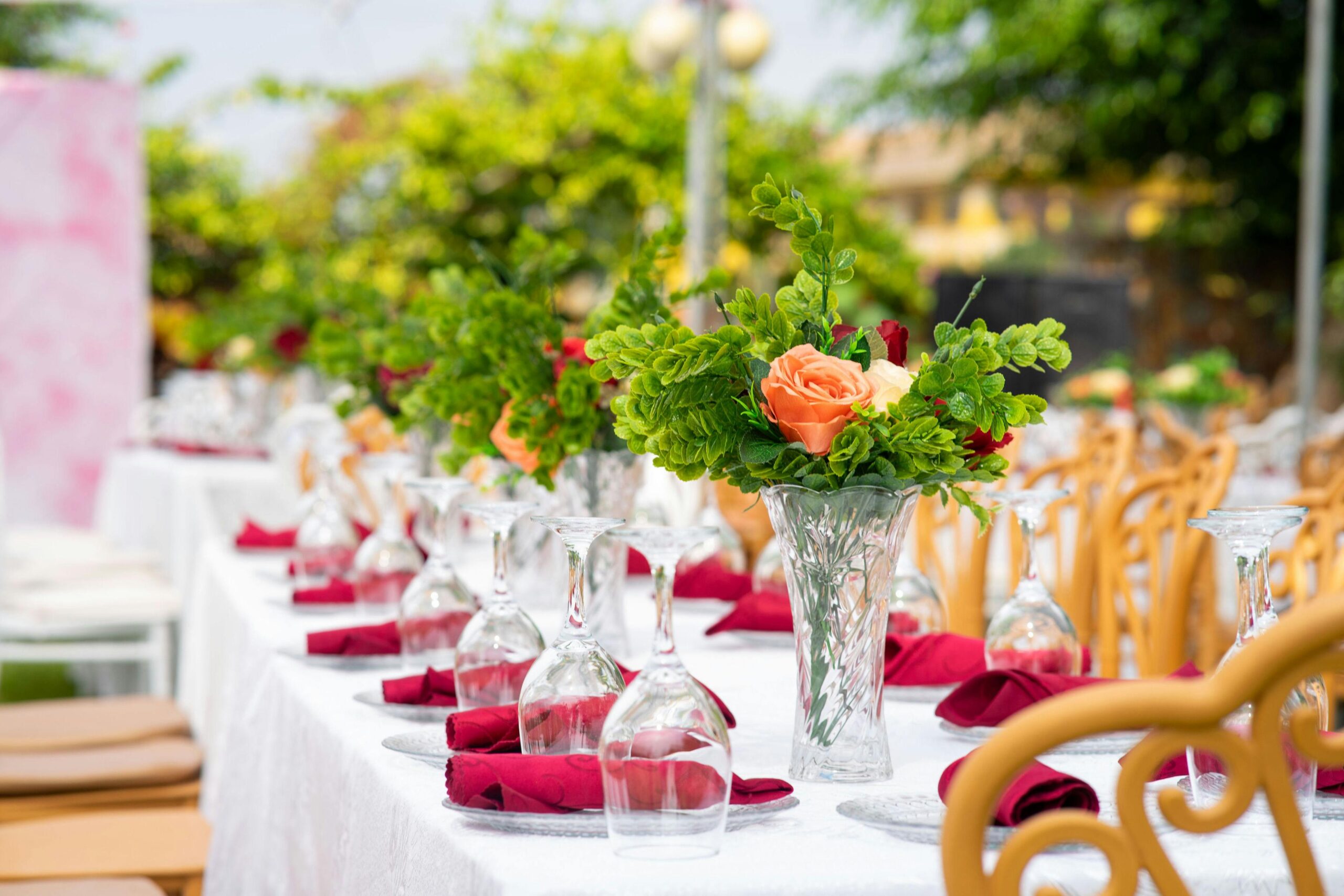 Beautifully decorated table with floral centerpieces at an outdoor reception.