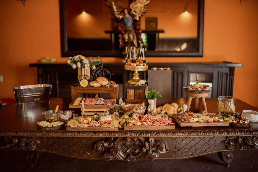 A beautifully arranged buffet table featuring a variety of cheeses, cold meats, and elegant decor.